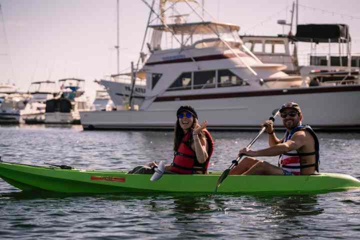 a group of people riding on the back of a boat in the water