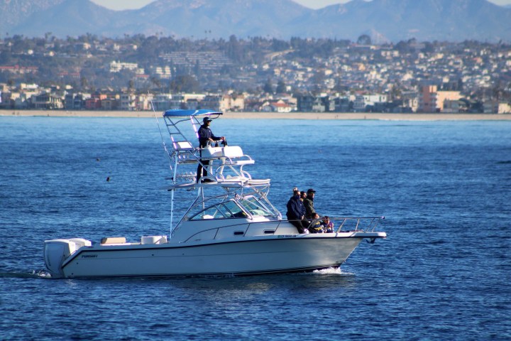 a small boat in a body of water with a city in the background